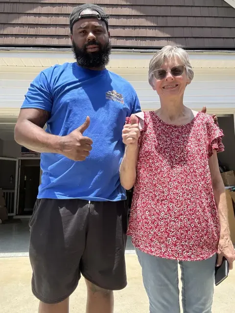 Kentuckiana Moving crew standing with branded moving trucks